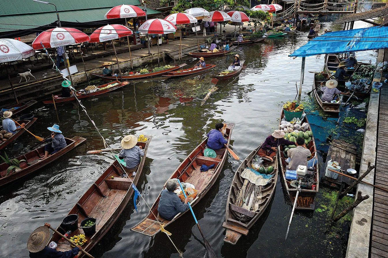 Vendors selling food from boats at a canal market near Bangkok, Thailand