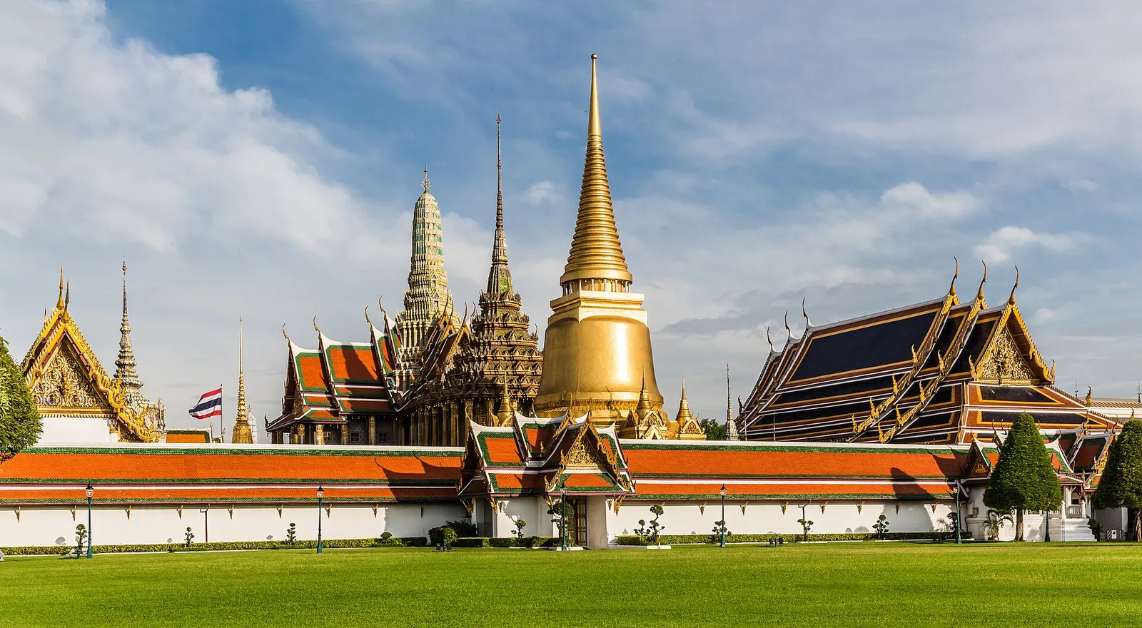 Golden spires and ornate rooftops of Wat Phra Kaew at the Grand Palace in Bangkok on a clear day