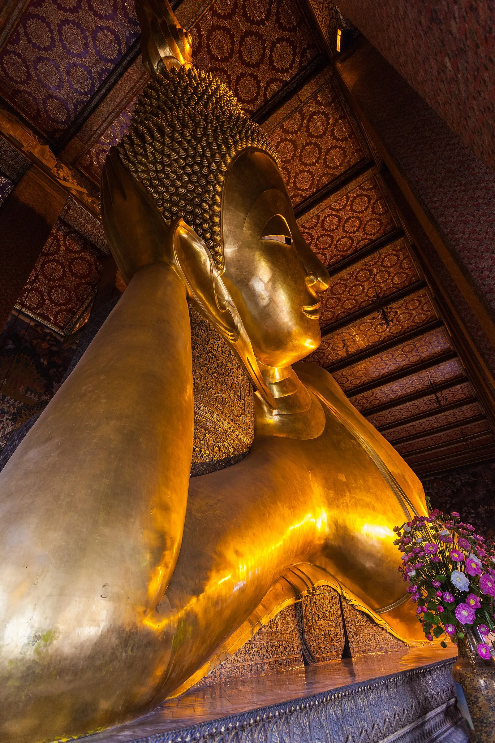 The gilded reclining Buddha filling the hall at Wat Pho in Bangkok, Thailand