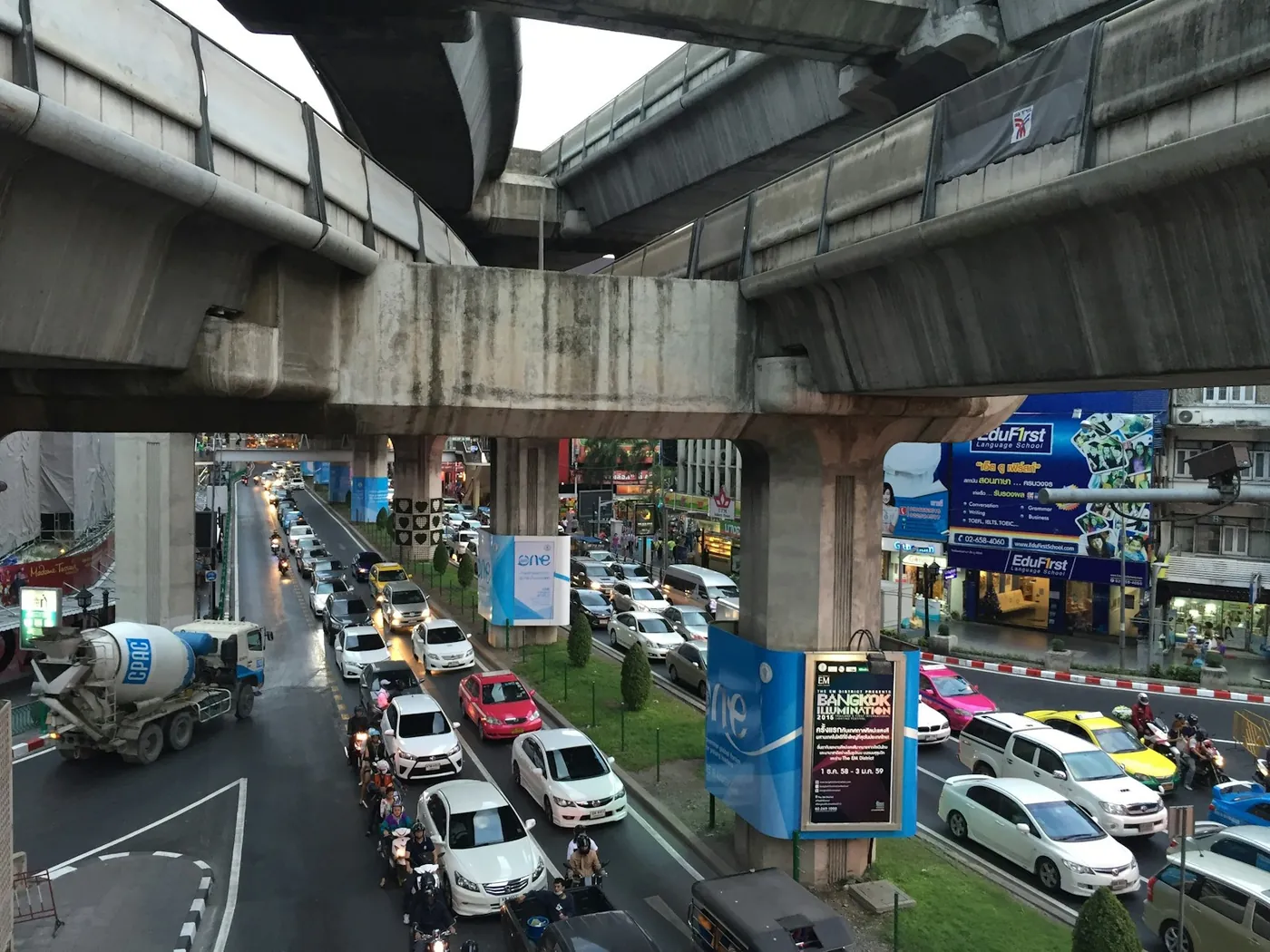 An elevated skytrain running above a busy road in Bangkok, Thailand