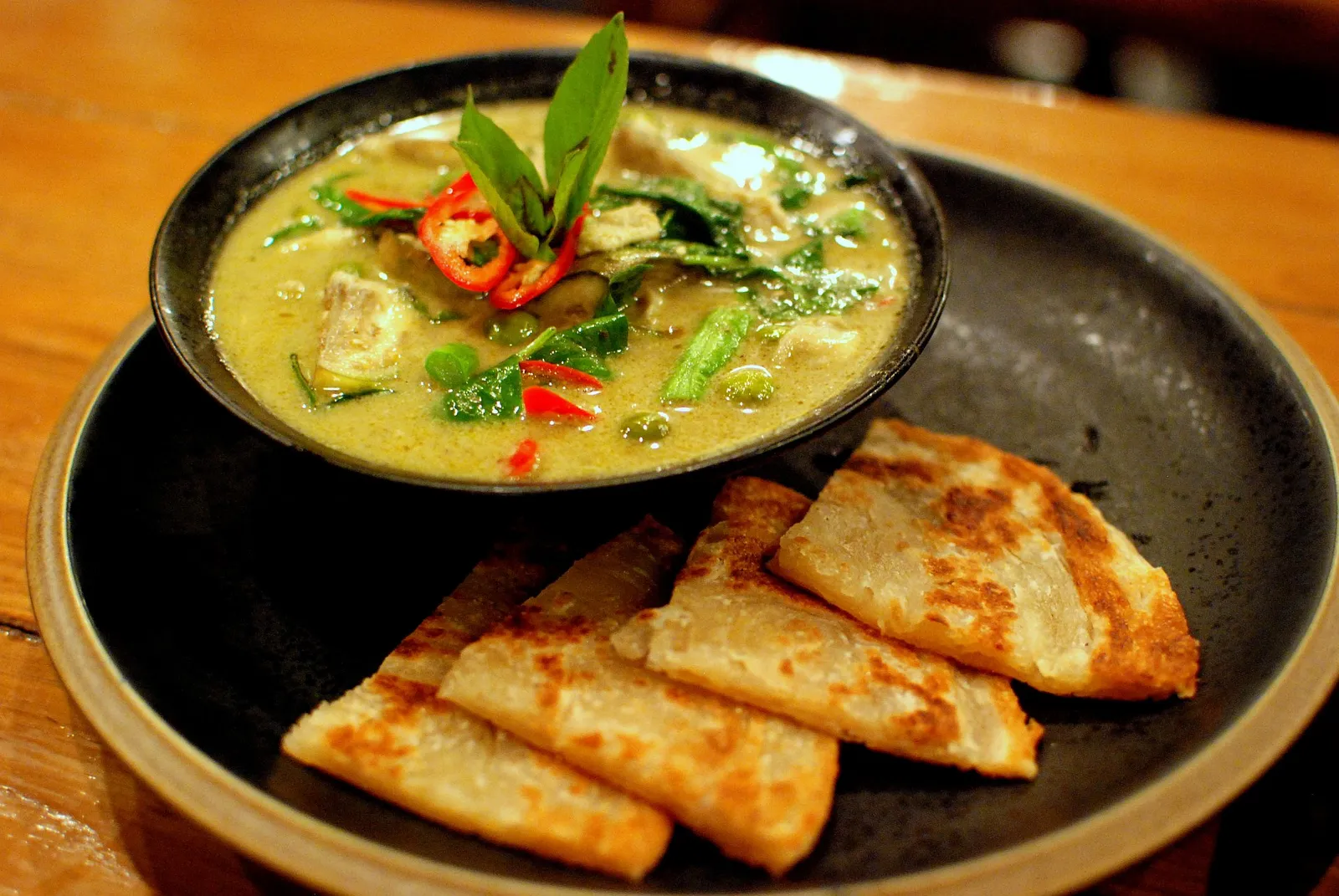 A green curry served with roti at a restaurant in Bangkok, Thailand