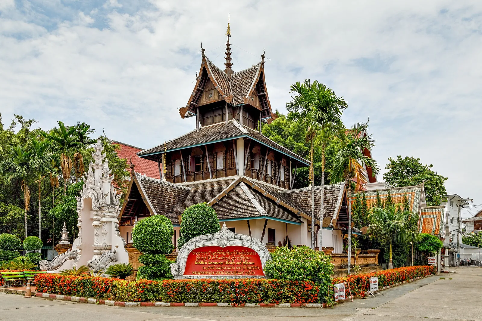 A temple with tiered wooden roofs and gardens in Chiang Mai, Thailand