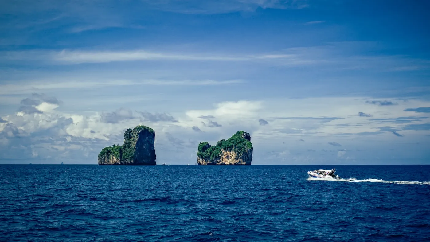 A passenger ferry crossing calm water between Thai islands