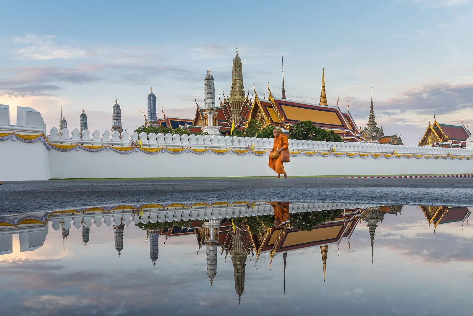 Golden temple spires glowing at sunset over Bangkok on a clear evening in Thailand