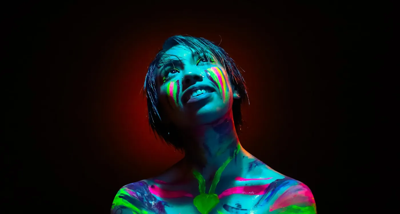 Fluorescent body paint glowing under blacklight