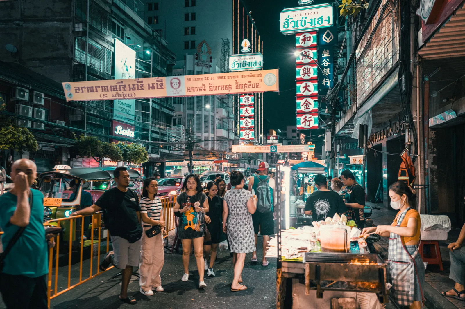 Steaming woks and street food stalls lit up after dark on Yaowarat Road in Bangkok's Chinatown