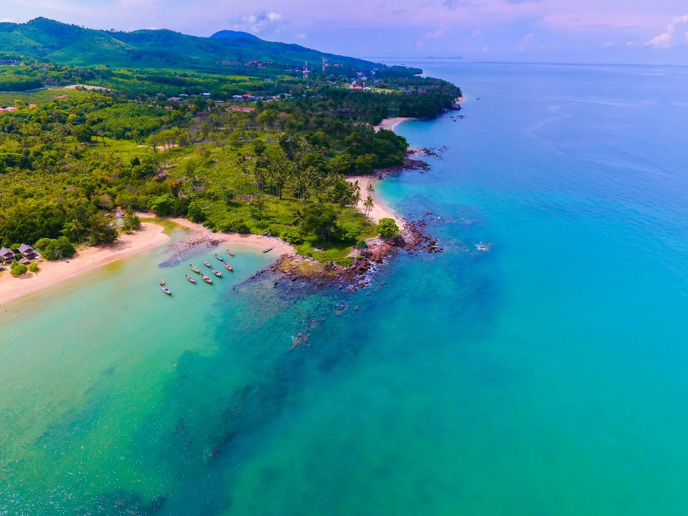 A private beach cabana and sun loungers facing a calm turquoise bay in southern Thailand