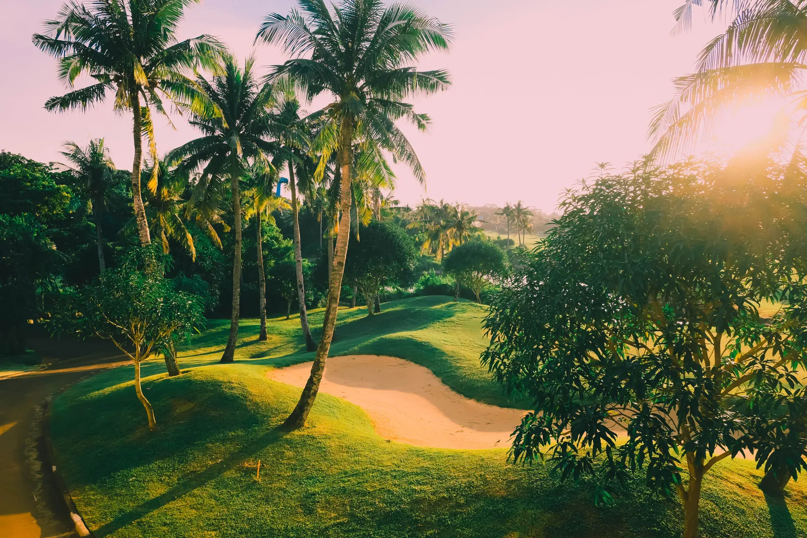 A green golf course fairway with palm trees near Hua Hin, Thailand