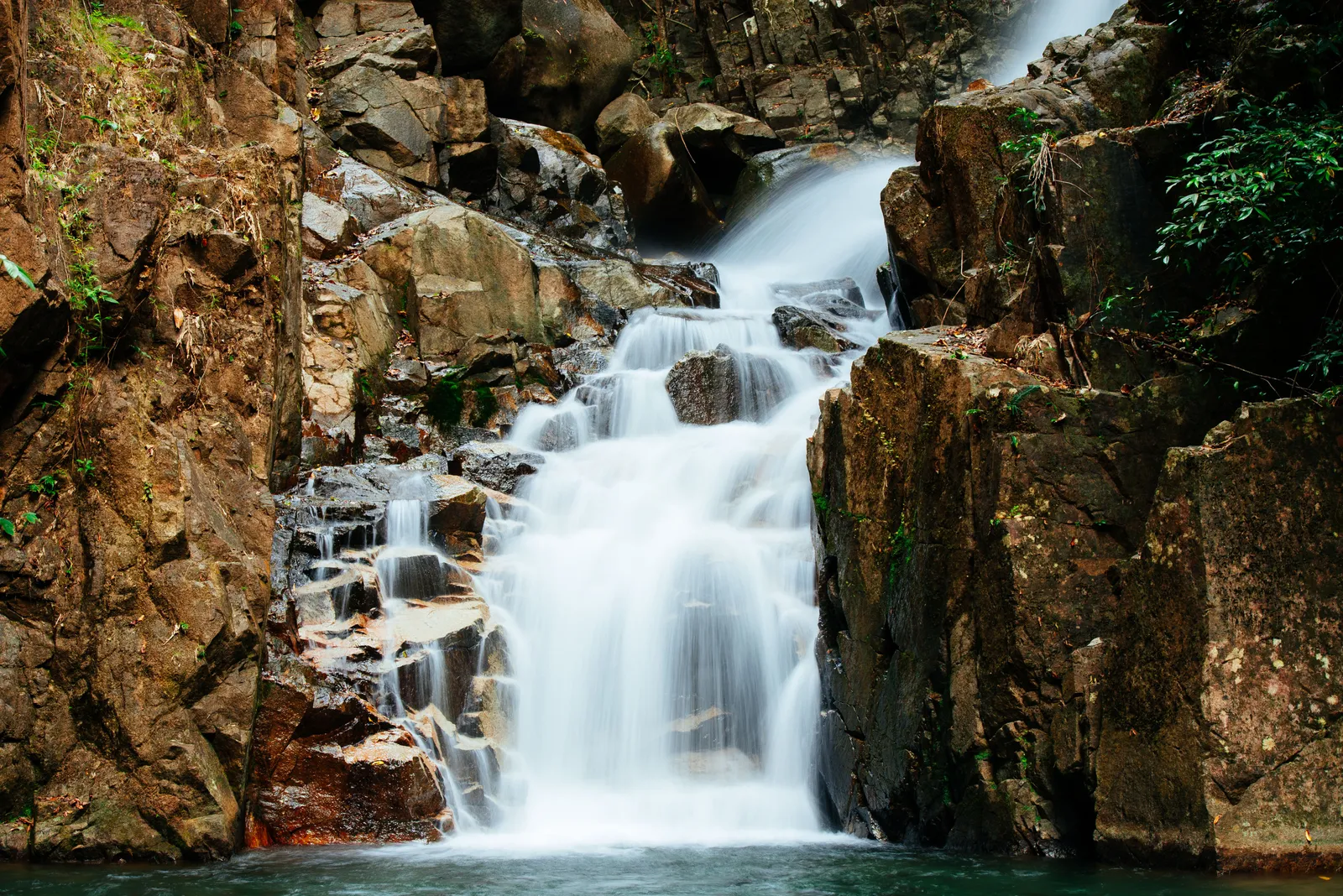 A tiered waterfall cascading through forest at Khao Yai National Park, Thailand