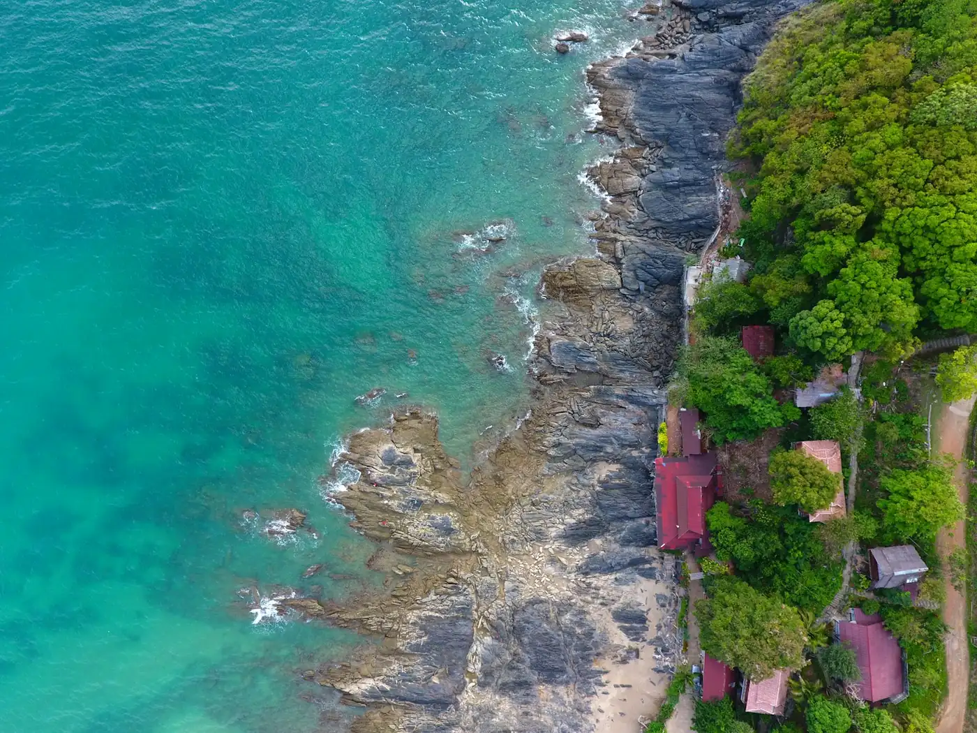 A rocky shoreline and calm sea on the coast of Koh Lanta, Thailand
