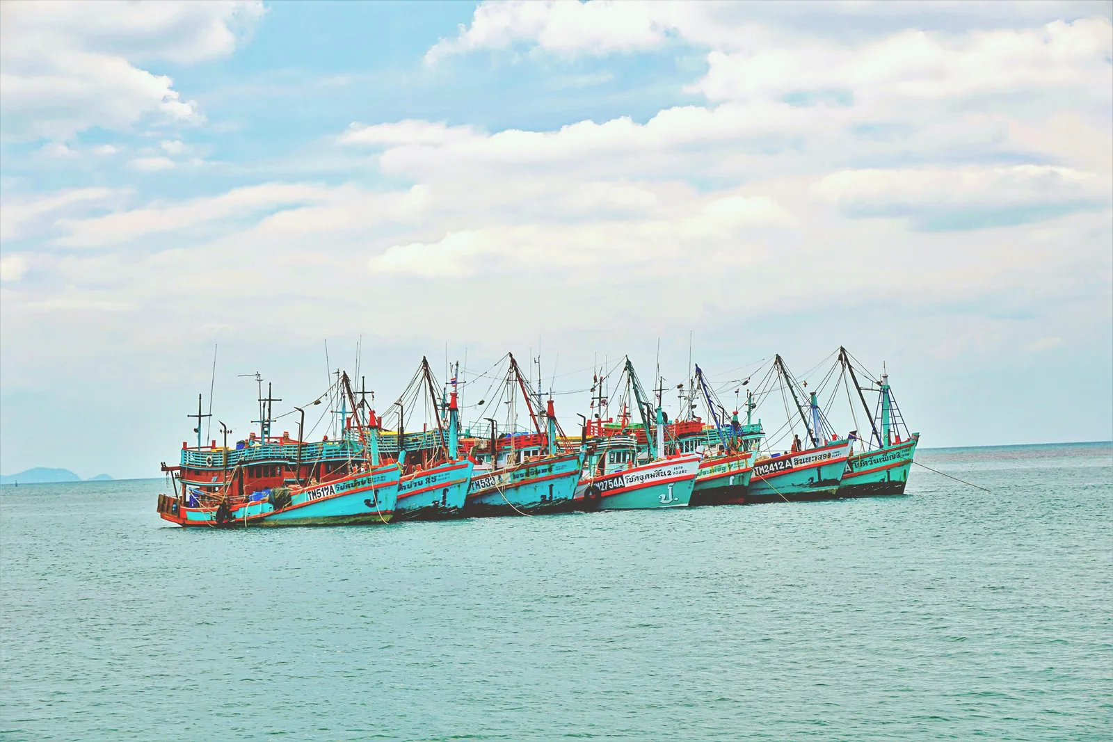 Wooden fishing boats moored offshore on the north coast of Koh Phangan, Thailand