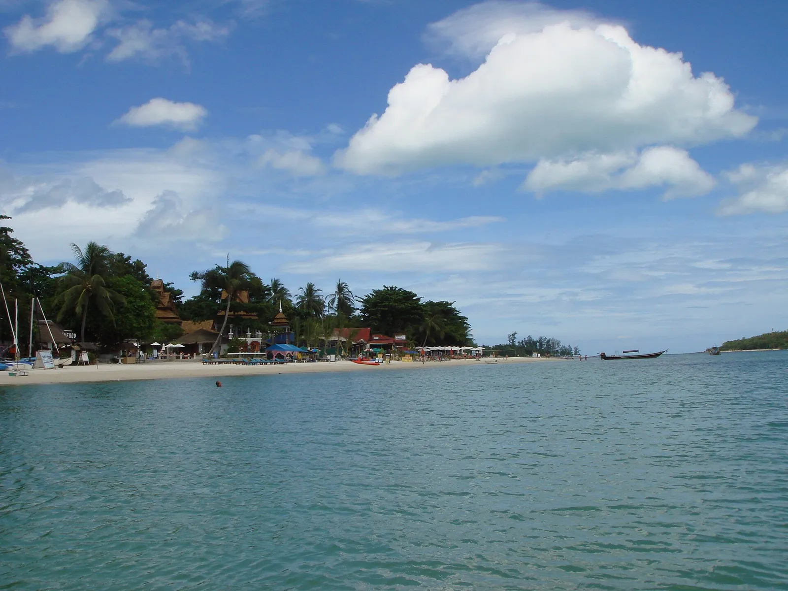 A palm-fringed white sand beach and turquoise water on Koh Samui in the Gulf of Thailand