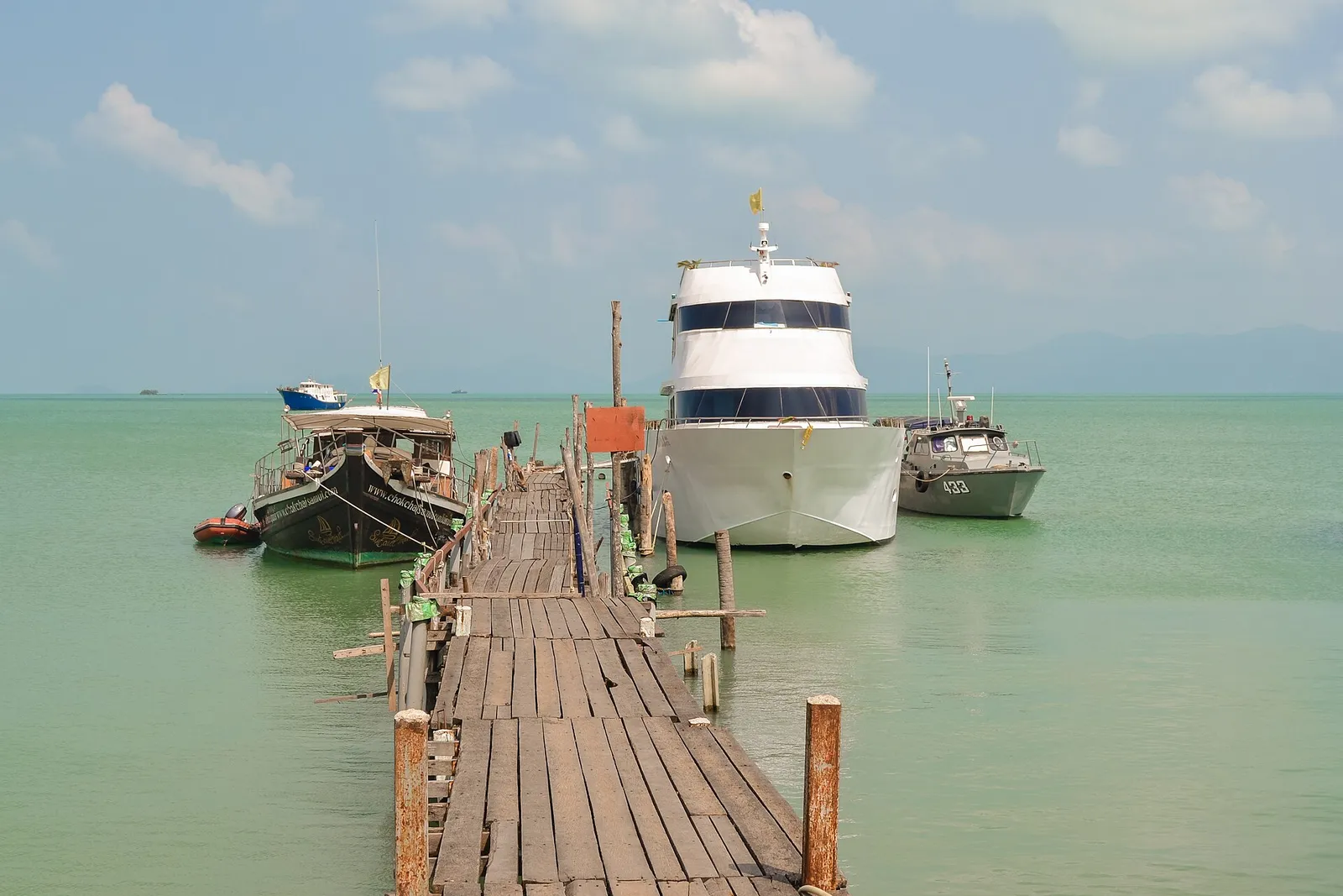 A pier with boats and village buildings on Koh Samui, Thailand