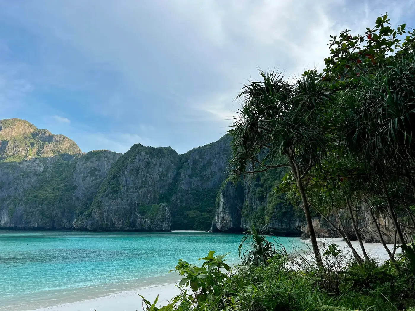 Turquoise shallow water and a green headland at Koh Phi Phi, Thailand