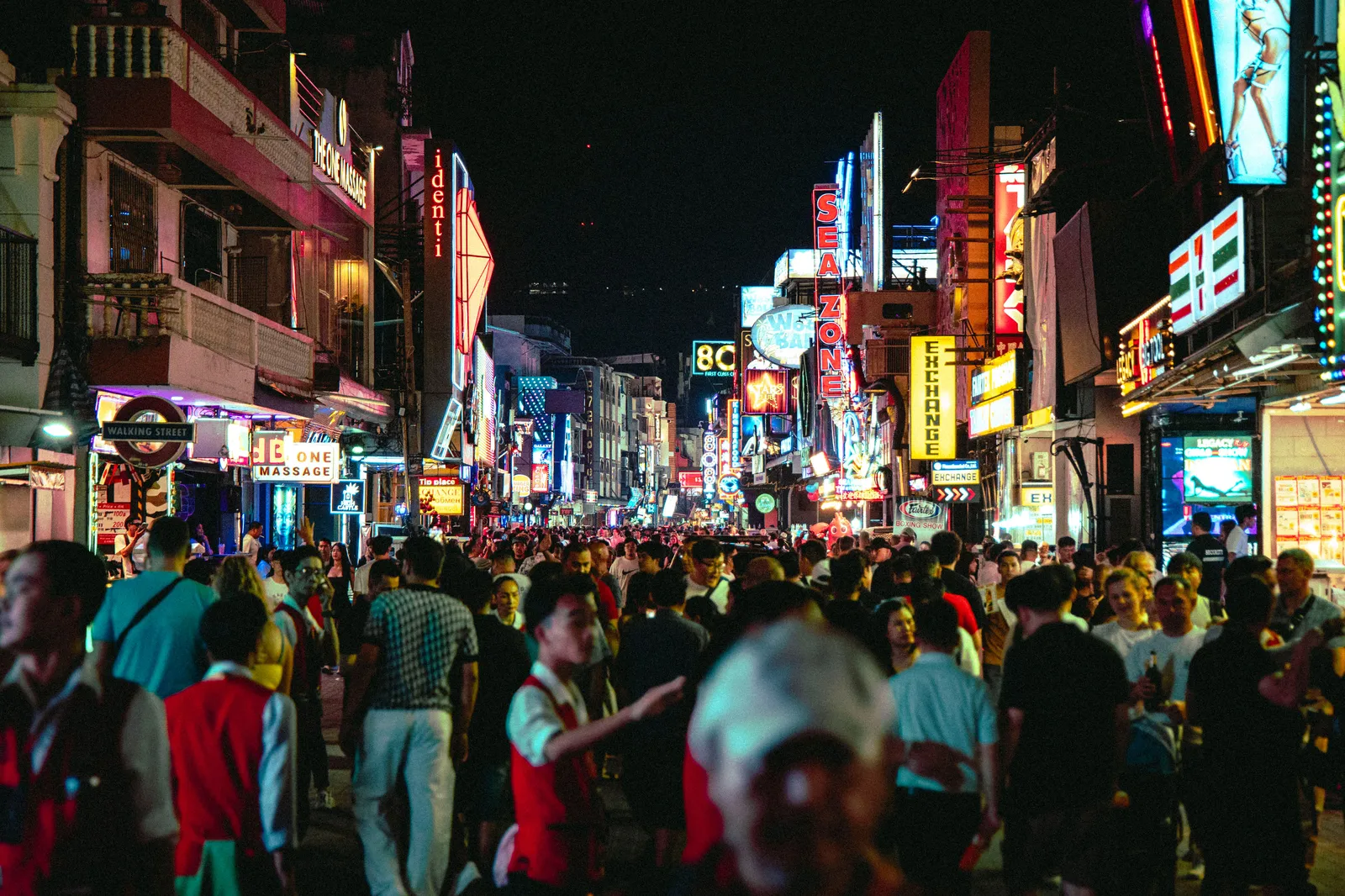 neon lit bar fronts and crowds on Bangla Road in Patong, Phuket, Thailand, at night