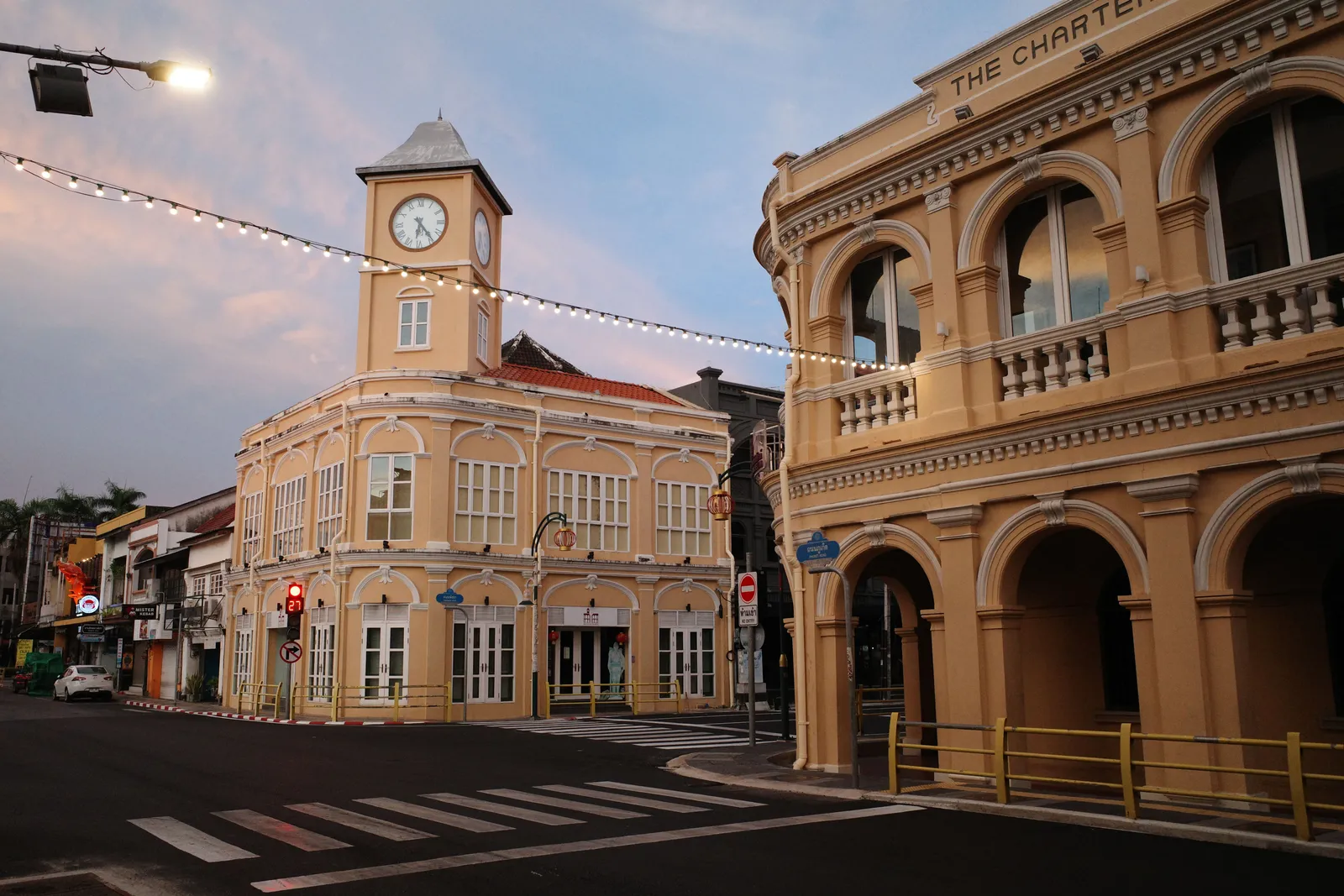 Old Sino Portuguese shophouses and the clock tower on a quiet street in Phuket Town, Thailand, in daylight