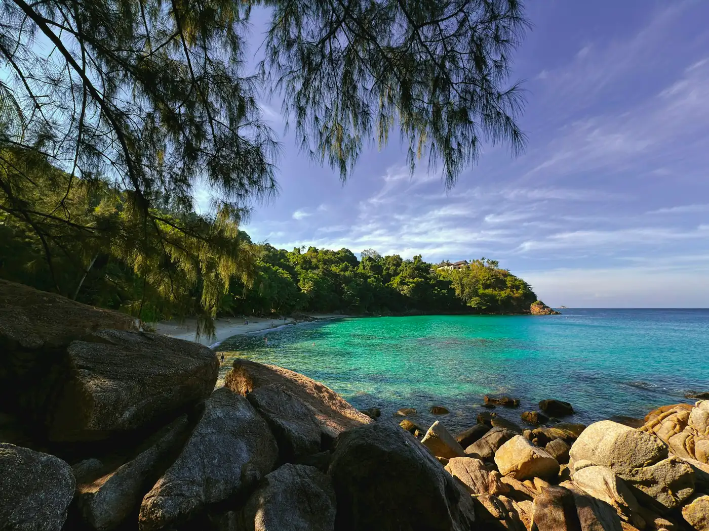 A calm bay with clear water and rocks on the coast of Phuket, Thailand