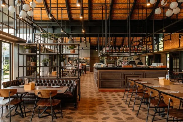 A high hall with metal shelving, brown leather benches and a drinks counter in the center