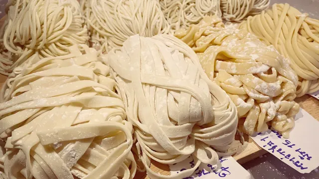 Nests of fresh floured noodles of different kinds side by side
