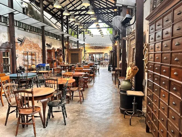 An antiques hall with a wooden drawer cabinet, tables and chairs in mixed styles