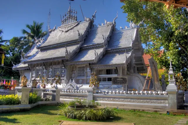 A temple hall clad in silver panels with fine relief work and tiered roofs