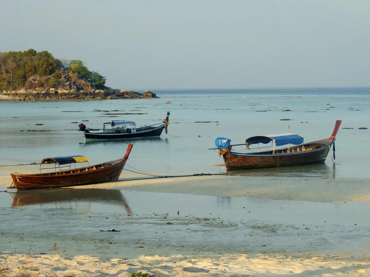 Longtail boats moored in the shallows off Sunrise beach on Koh Lipe