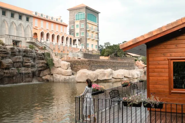 European style buildings on a lake shore, a wooden deck with flower boxes