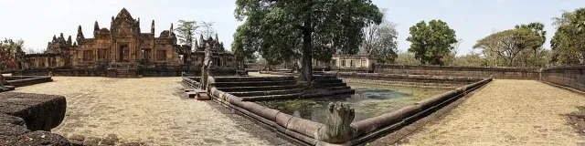 A laterite stone sanctuary with serpent balustrades and water ponds in an open compound