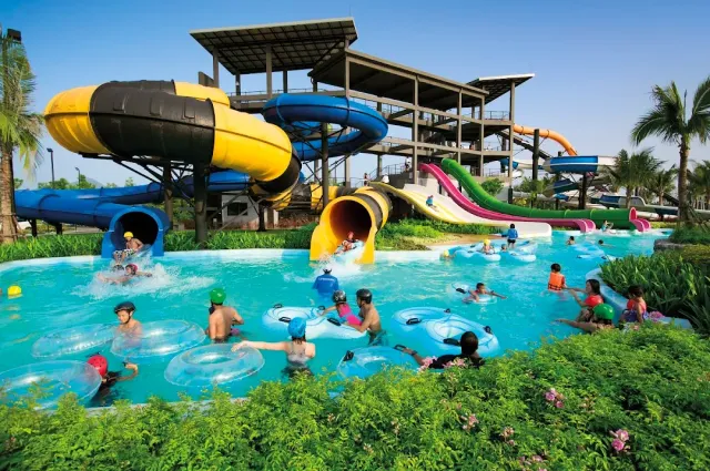 Yellow and blue slides emptying into a pool with bathers on rubber rings