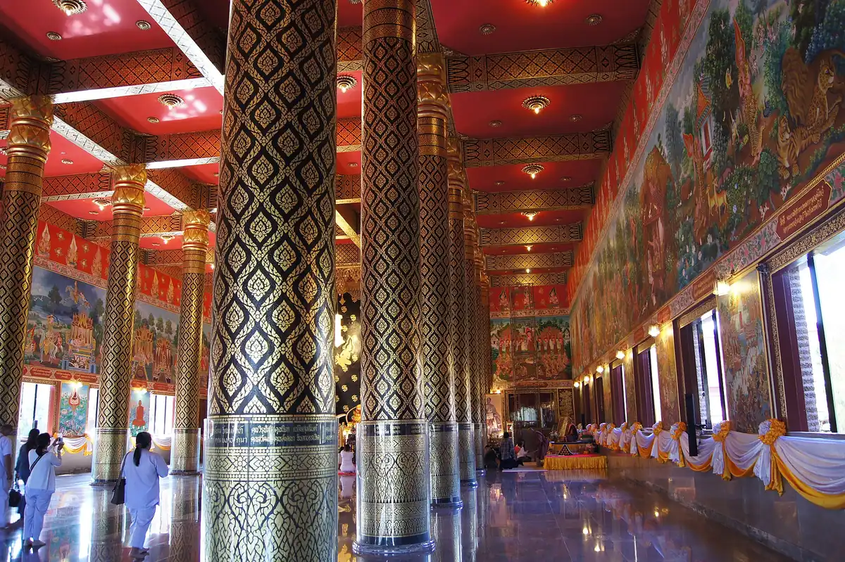 Temple hall with columns in a diamond pattern, a red ceiling and murals along the walls