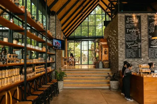 A tall wooden hall with shelves of jars, menu boards and a glass front to the garden