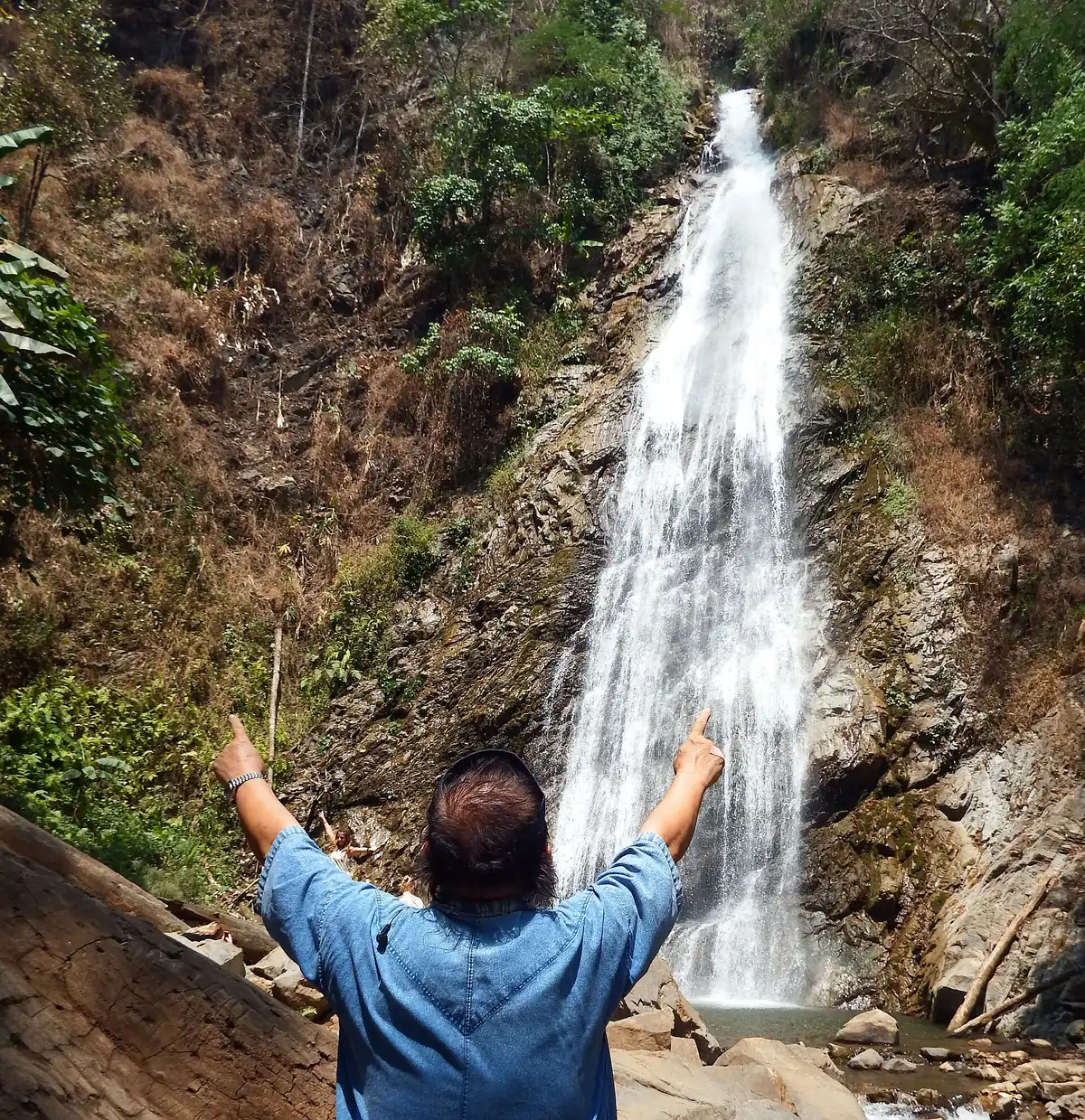 The Khun Korn waterfall dropping down a wooded slope