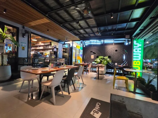A seating area with a wooden table, white chairs and a circles motif on the wall