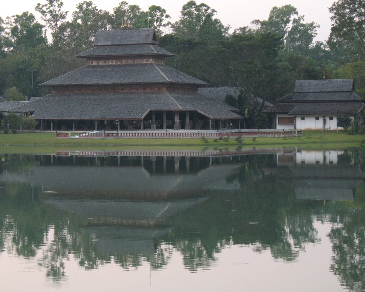 The great timber hall of Rai Mae Fah Luang reflected in the water
