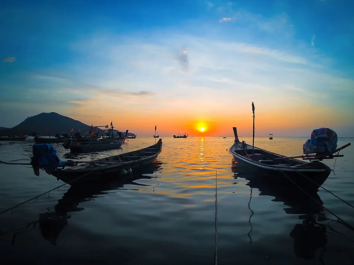 Longtail boats at sunset on the Sirinat park shore