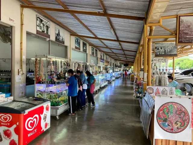 A covered aisle with glass display cases of gemstones, shoppers examining the goods