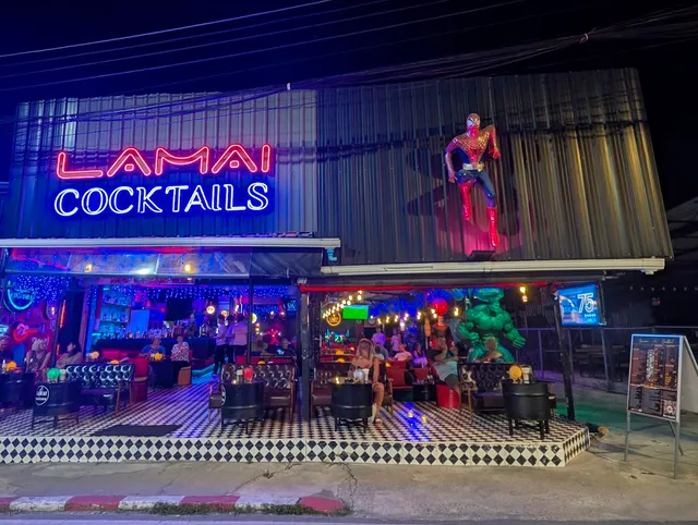 A bar open to the street with a black and white checkered floor, sofas and superhero statues