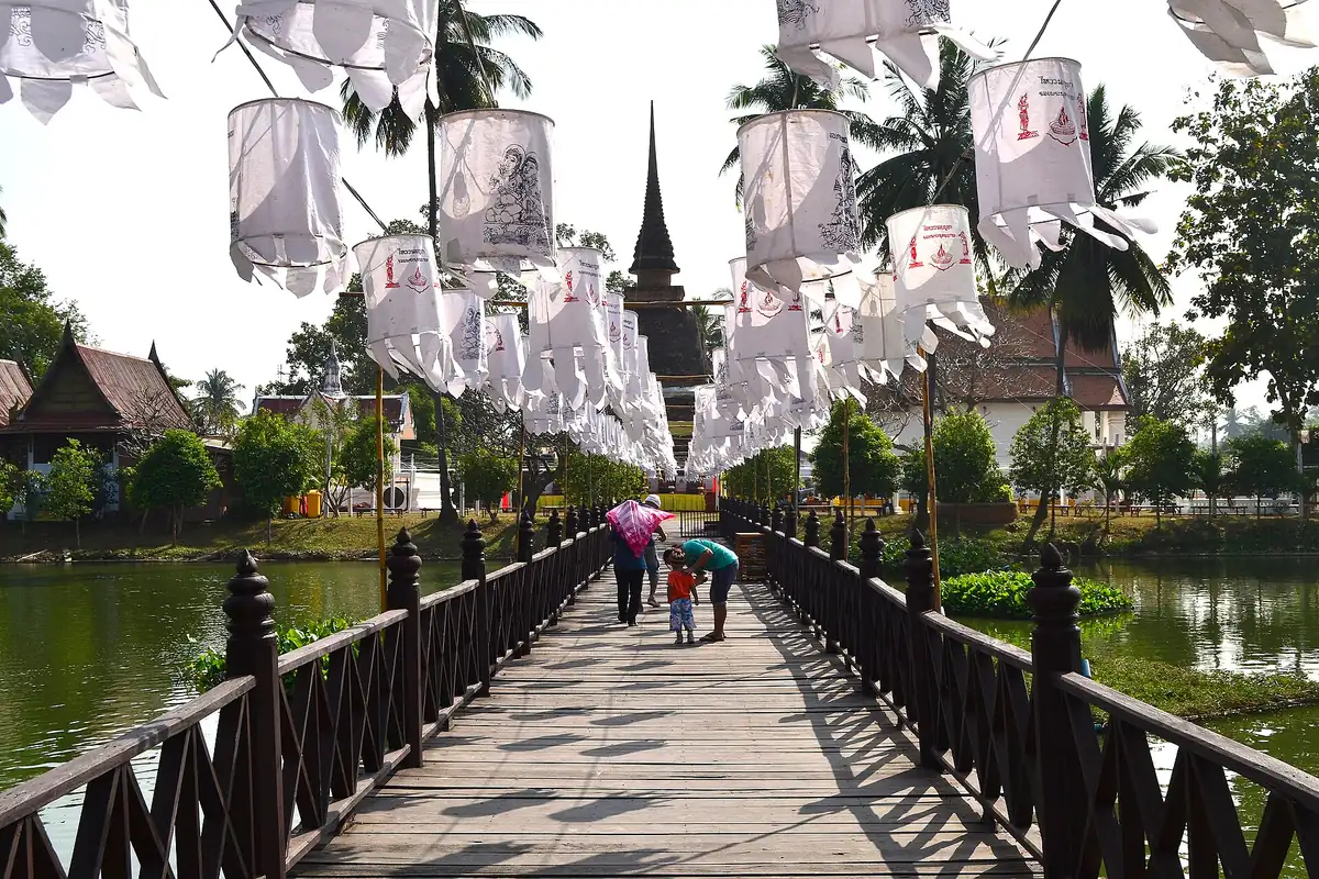 The causeway to Wat Traphang Thong in Sukhothai hung with paper lanterns