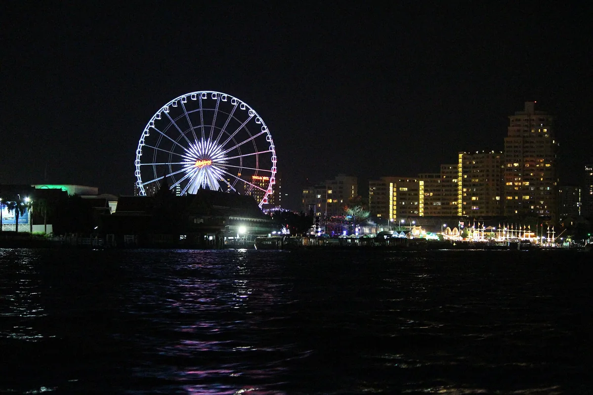 The Asiatique ferris wheel lit above the Chao Phraya river at night