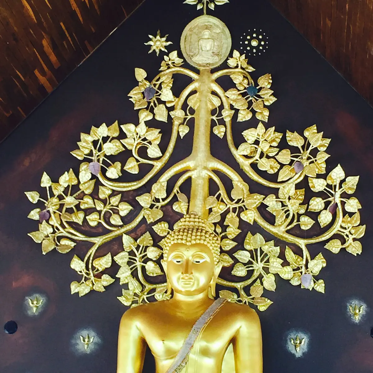 Gilded relief of a bodhi tree with many leaves and a Buddha head at its centre
