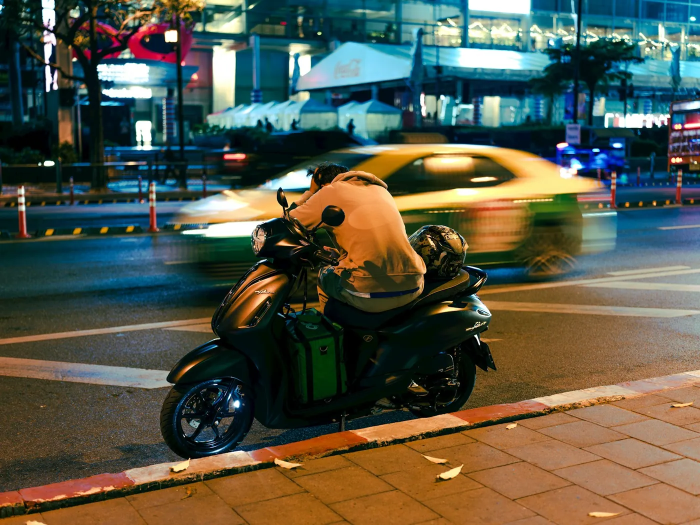 A rider wearing a helmet on a scooter in traffic in Thailand