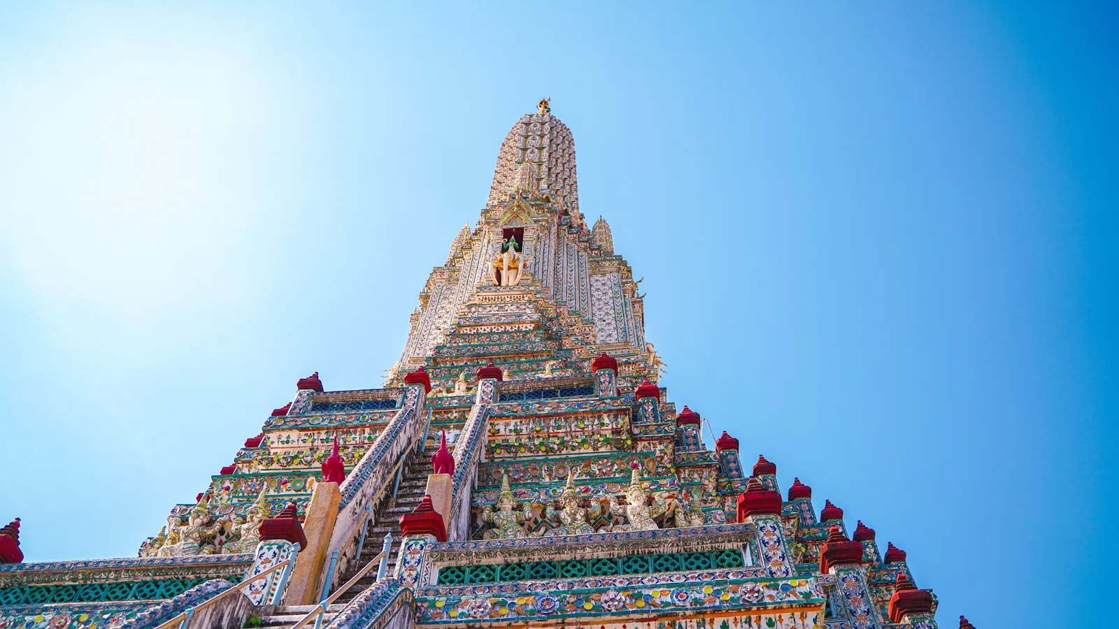 The porcelain-decorated spire of Wat Arun on the Chao Phraya riverbank in Bangkok