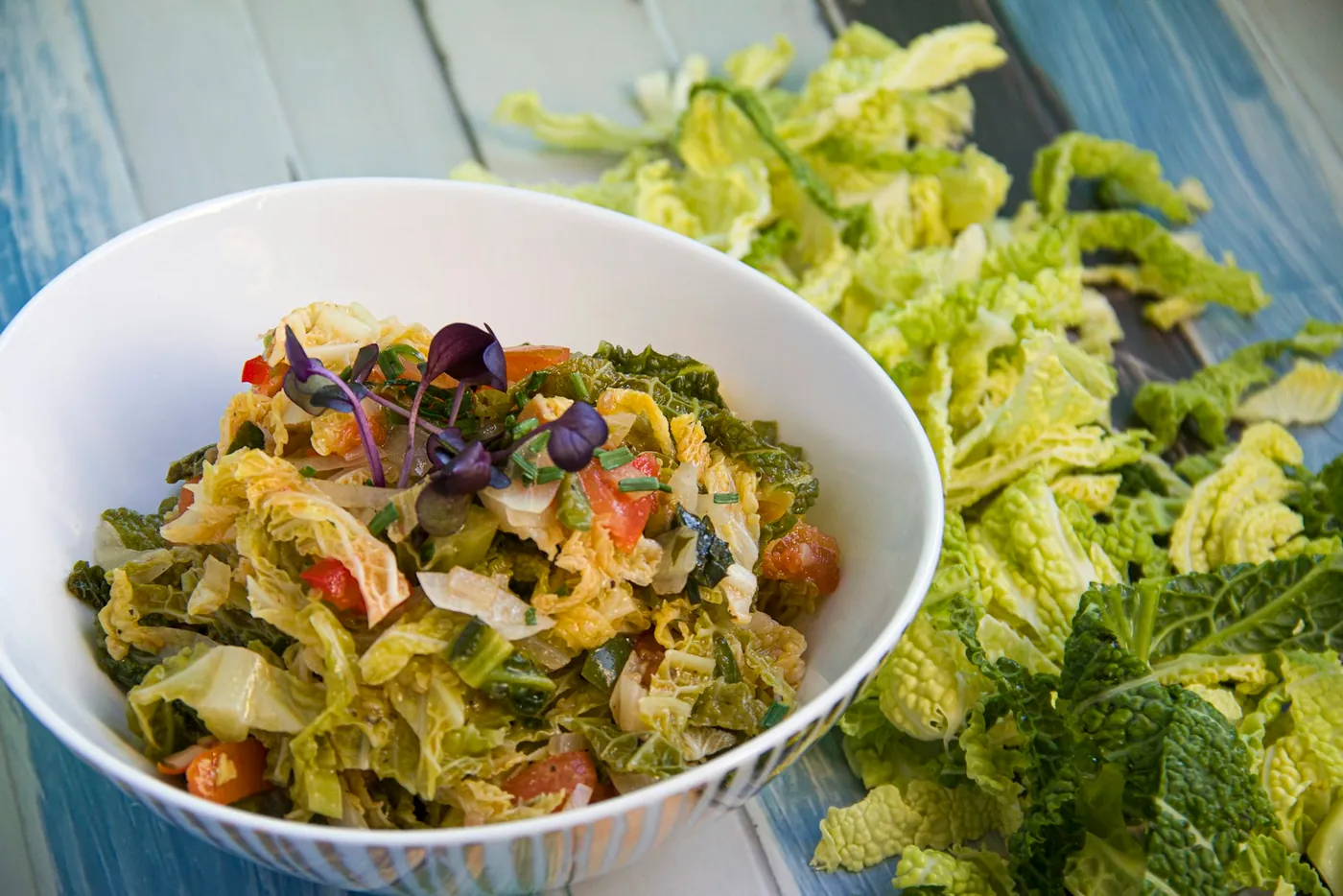 A close-up of a vegetarian green curry with cabbage, green beans and basil leaves in a rich coconut milk sauce, a plant-based take on a Thai classic