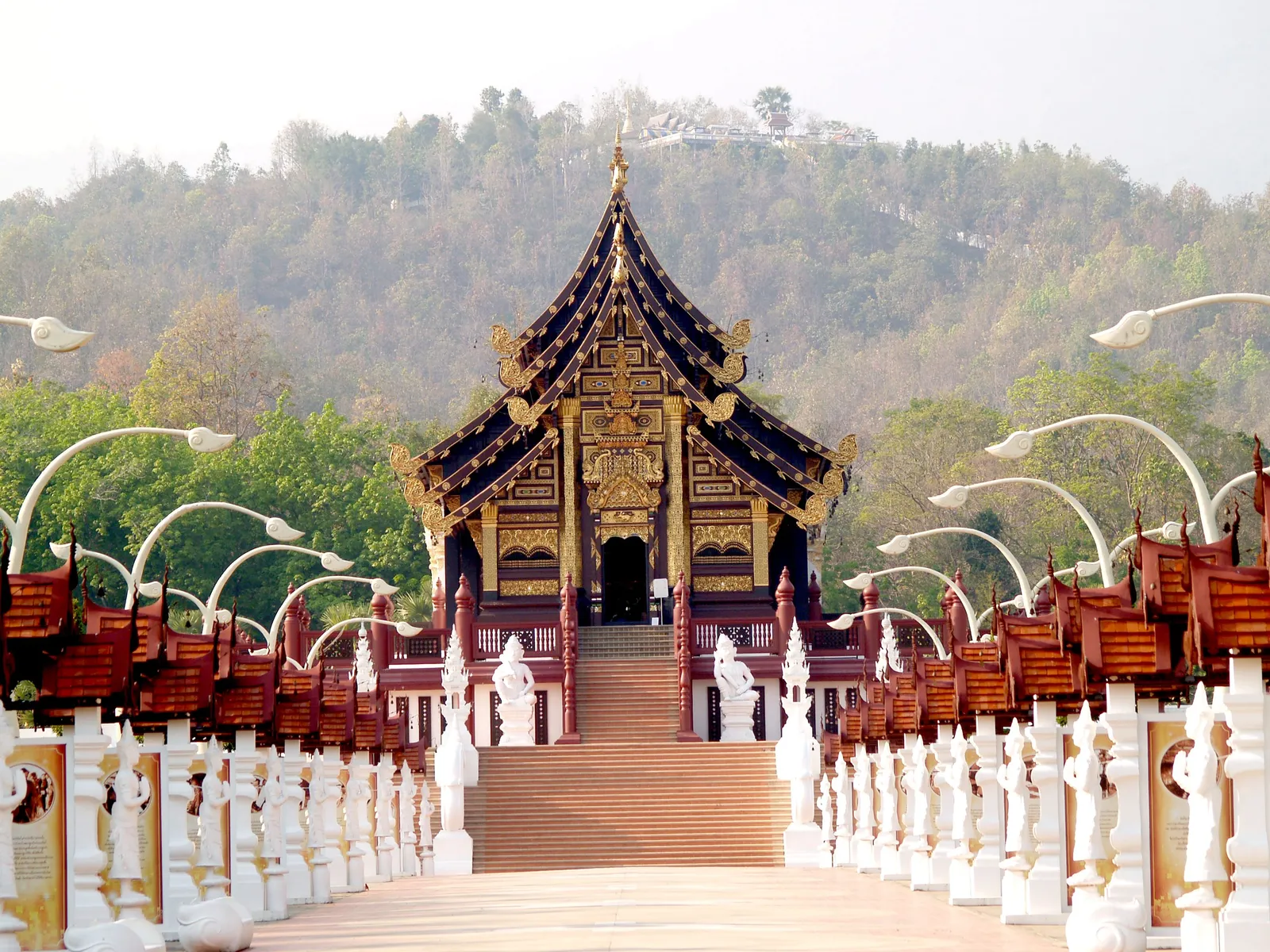 A temple with wooden buildings on a forested mountainside near Chiang Mai in northern Thailand