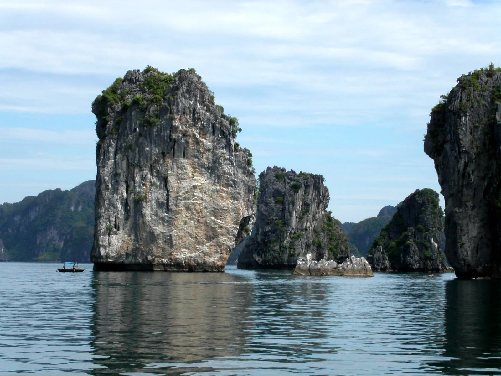 Limestone karst islands rising from green water in Ha Long Bay, Vietnam