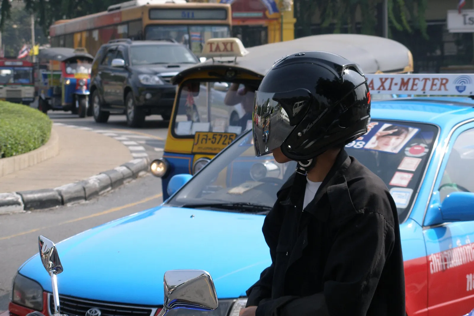 Dense motorbike and car traffic on a central Bangkok road in daylight, Thailand