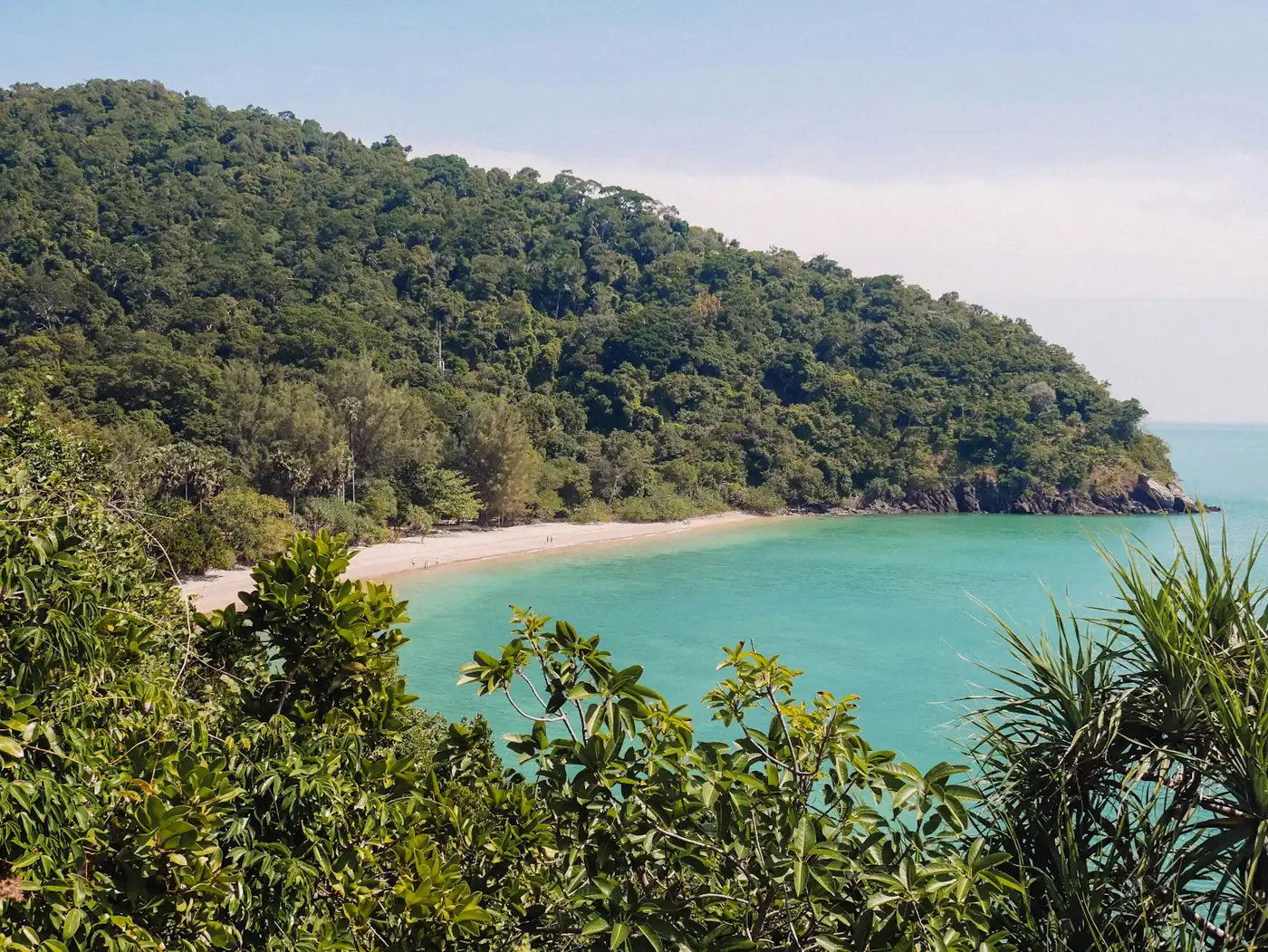 A quiet, jungle-fringed cove with calm turquoise water inside the national park on Koh Lanta, Thailand