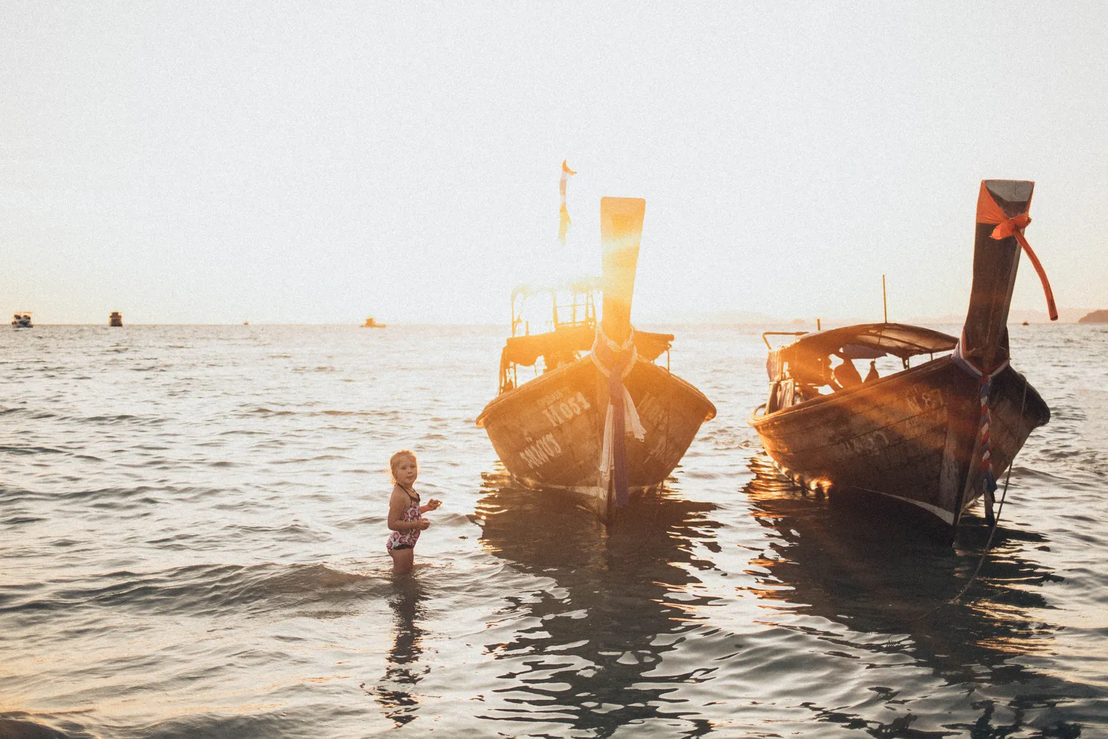 Children playing in shallow calm water at a gently shelving beach on the Thai coast